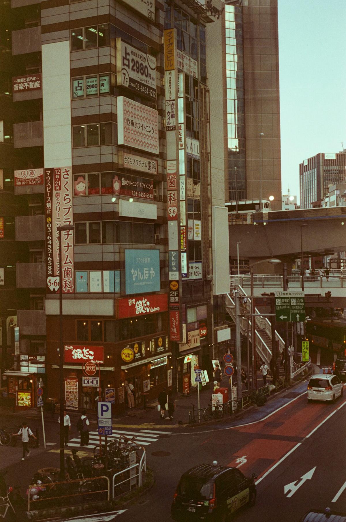 A Tokyo street corner with signage and tall buildings in afternoon light
